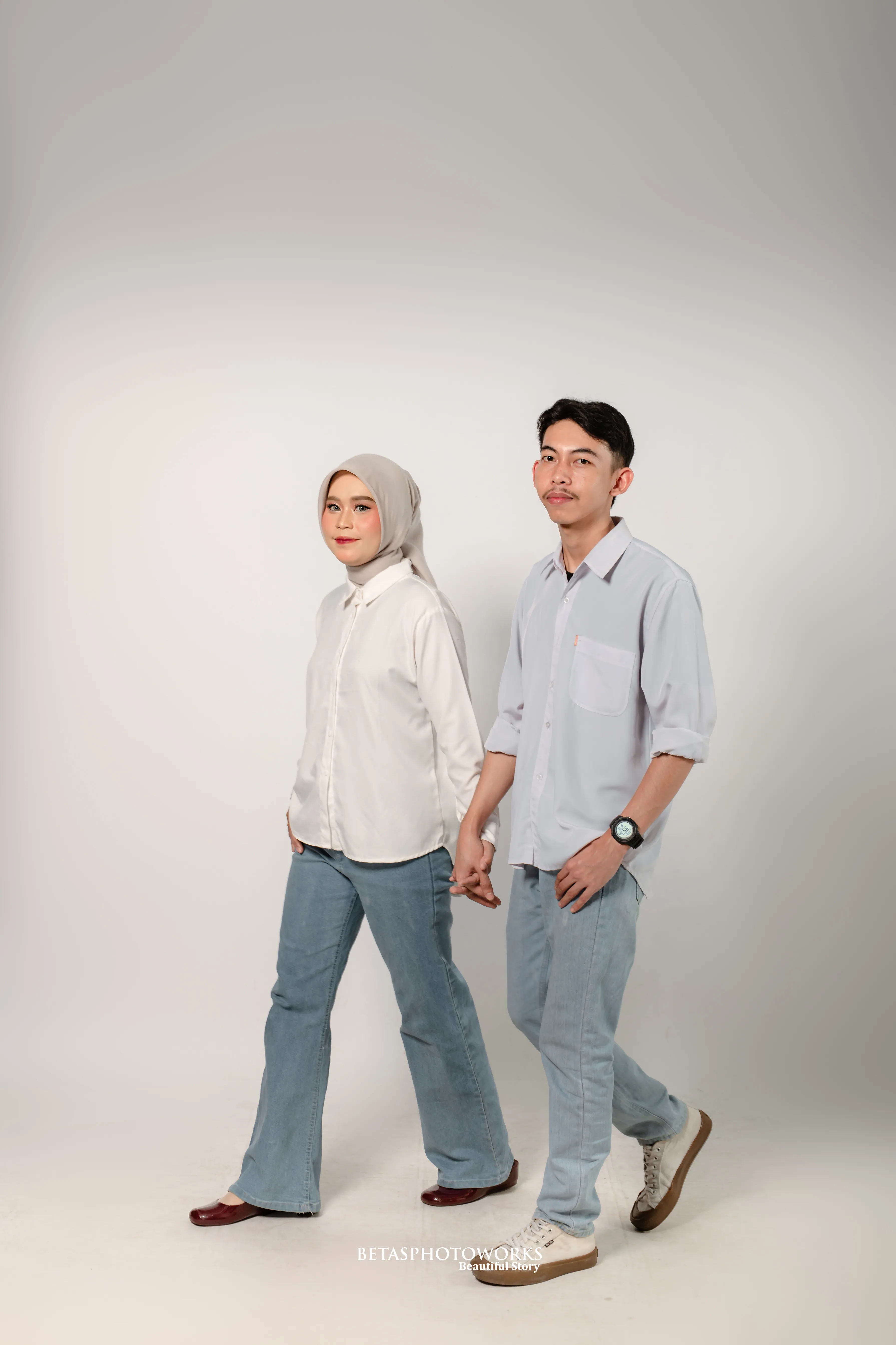 Tiara dan Roni berjalan berpegangan tangan